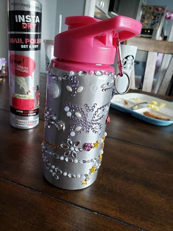 Reviewer's photo showing a a water bottle decorated with rhinestone glitter gem stickers