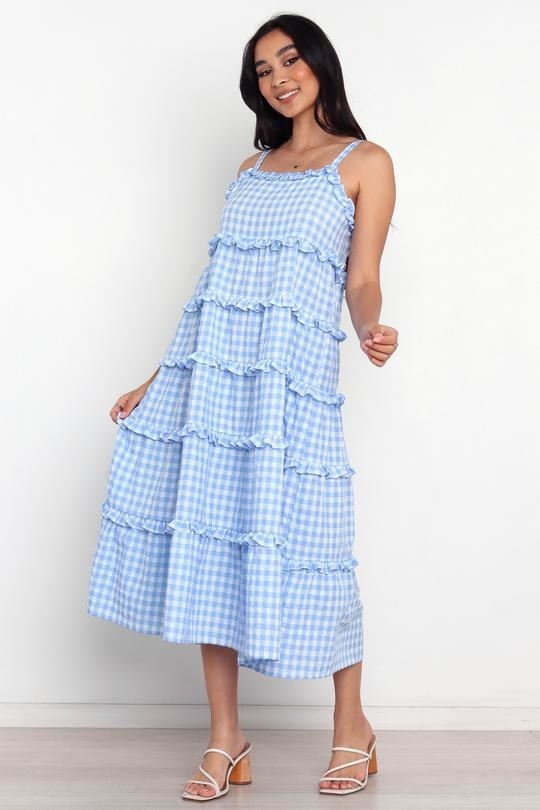 model in light blue and white sleeveless midi with ruffle details