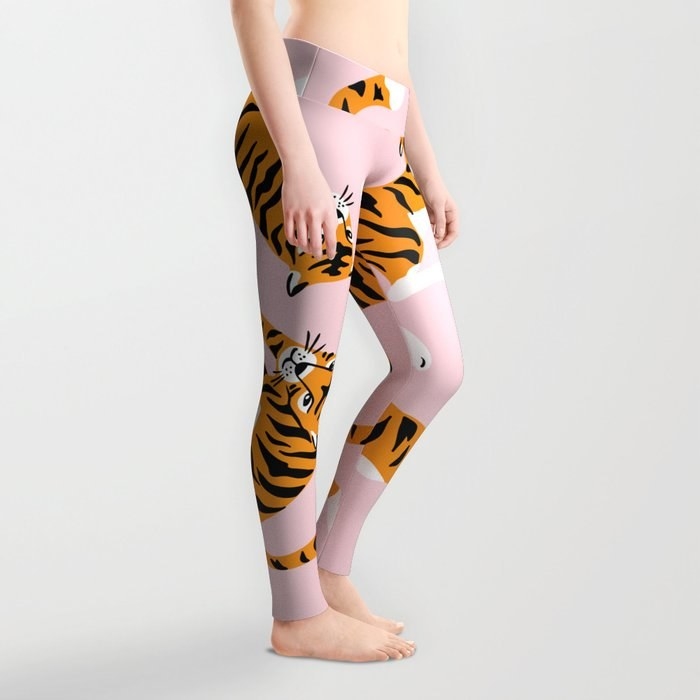 model in pale pink leggings printed with orange tigers