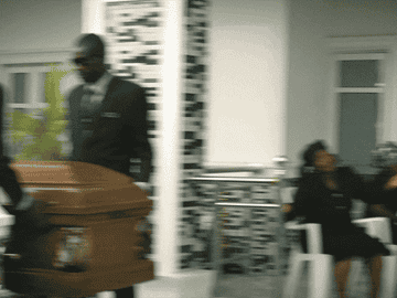 A woman running after a casket at the funeral