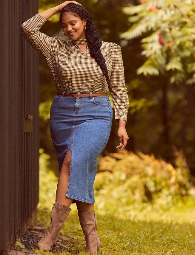 Model wearing a brown top with a denim midi skirt and brown boots