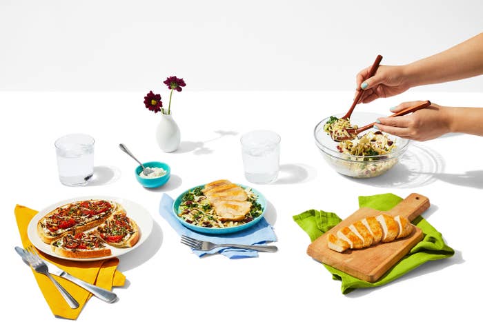 Table is set with flatbreads, grain bowls, and supplementary sides.