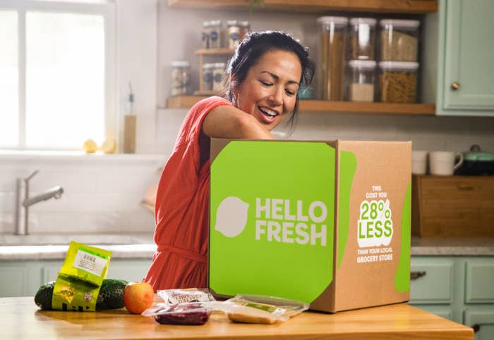 Person pulls produce from a cardboard HelloFresh box
