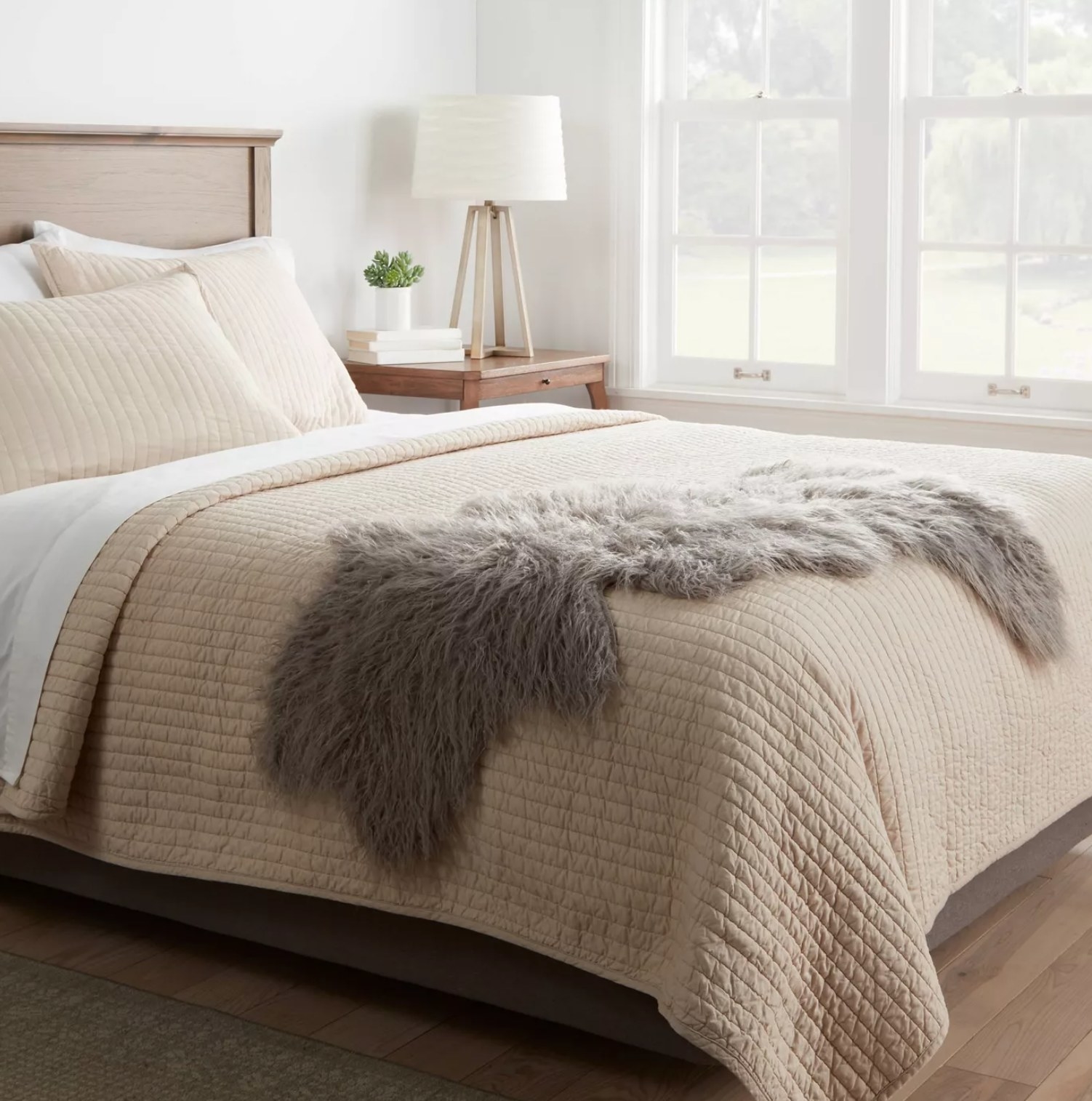 the brown sheepskin blanket on the bottom corner of a bed