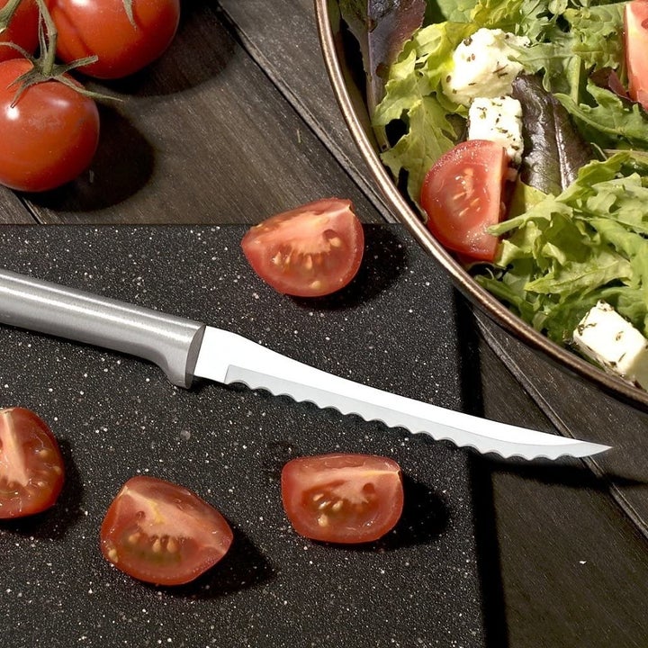 serrated knife with cut tomatoes