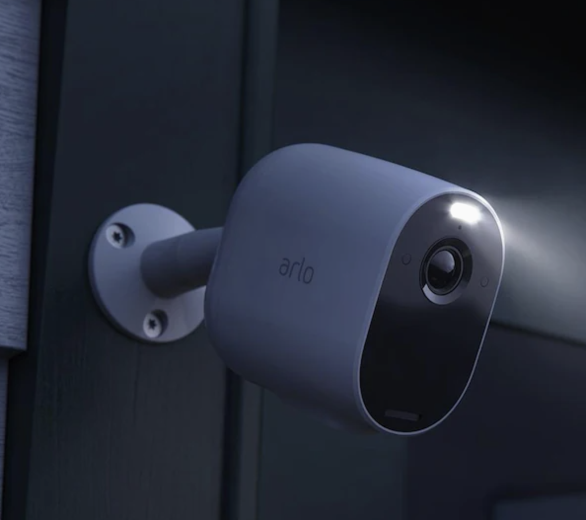 A compact white mounted camera on a door with a spotlight on