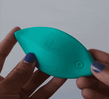 GIF of model demonstrating size and flexibility of green leaf-shaped vibrator