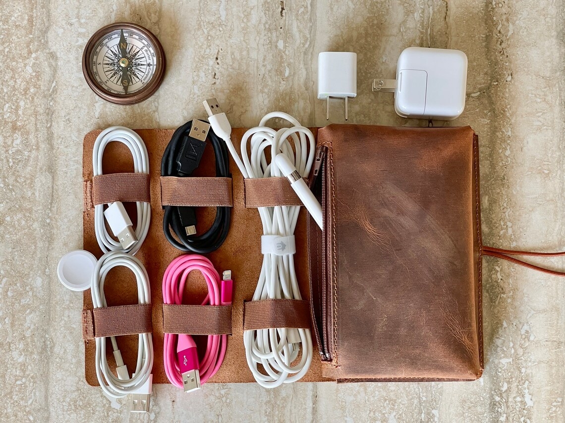the cable pouch, with six rolled-up cables on one side, and a zippered pouch with an apple pencil and two apple charging blocks on the other