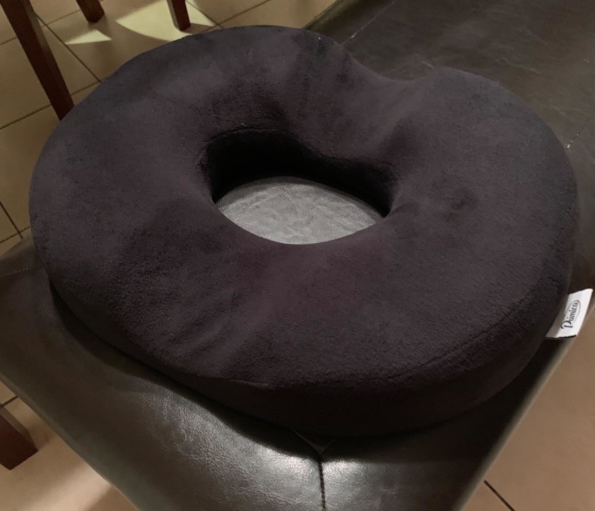 black donut-shaped pillow on a chair