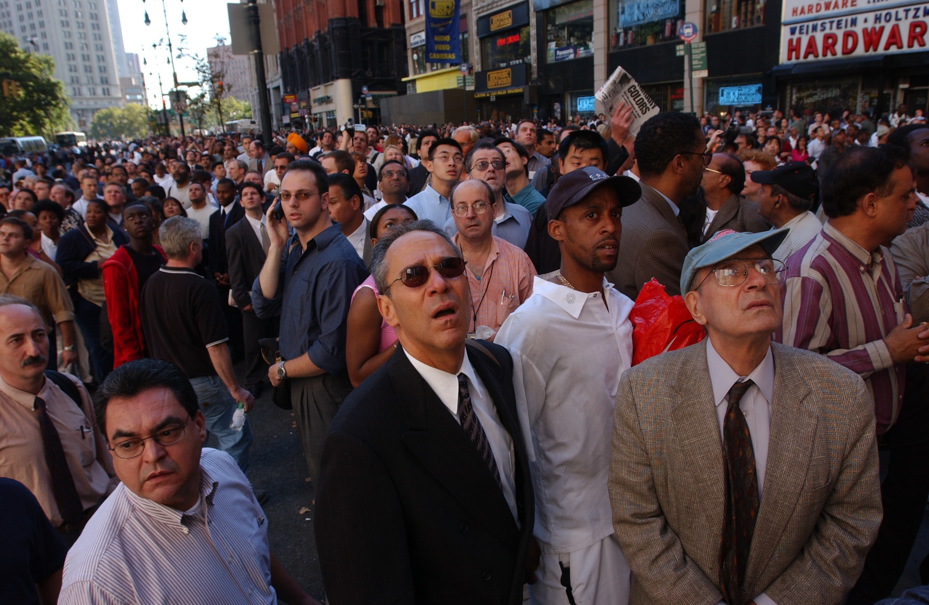 A crowd of people in business clothes looking up