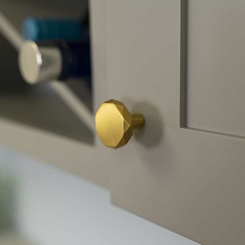 The cabinet knobs in the color Brushed Golden Brass