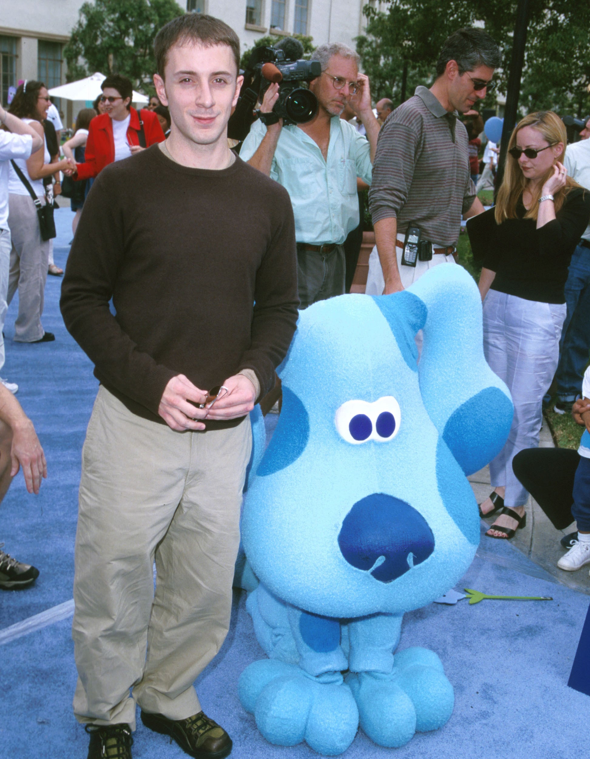 Steve standing on a blue carpet at an event next to a life-size Blue mascot