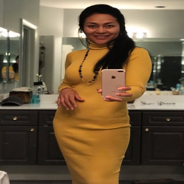 A reviewer wearing the below-the-knee dress in yellow