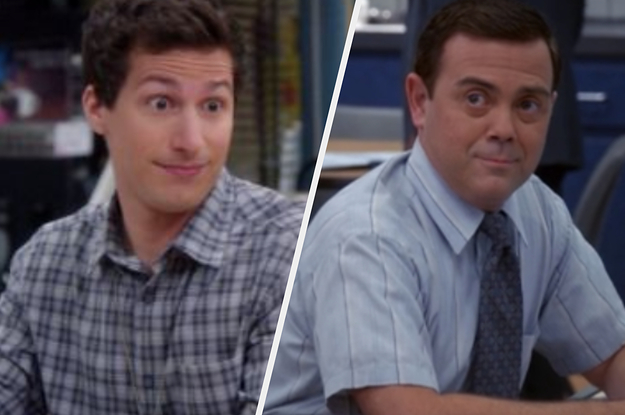 A close up of Jake with his eyes comically wide and Charles sits at his desk at the police precinct while he smiles at someone off screen