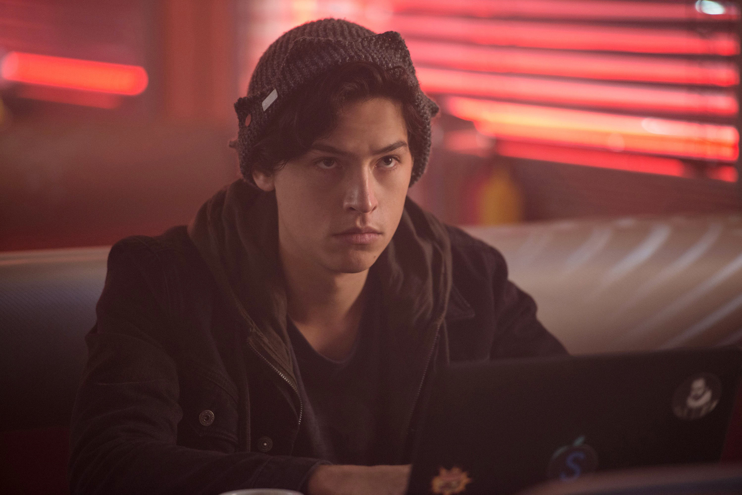 Cole Sprouse sitting at a diner in &quot;Riverdale&quot;