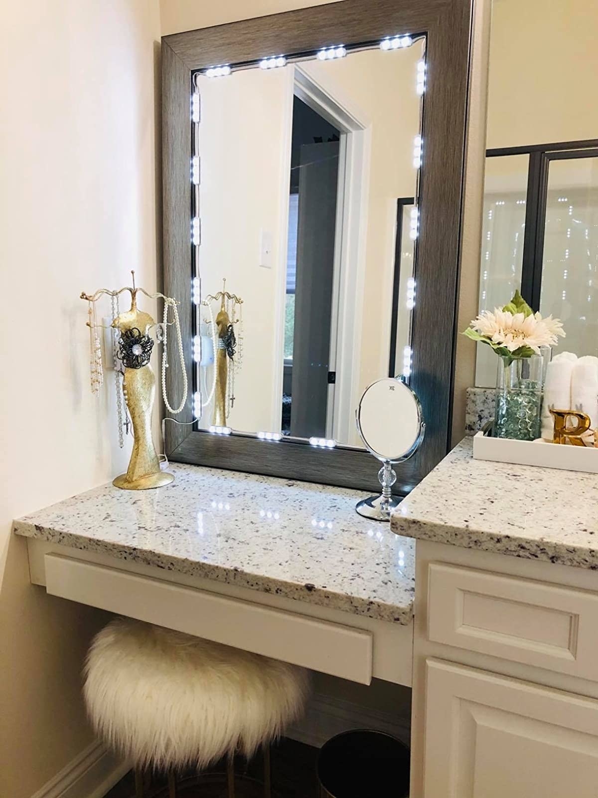 Reviewer&#x27;s vanity table in the corner of a bathroom shows the lights around a mirror