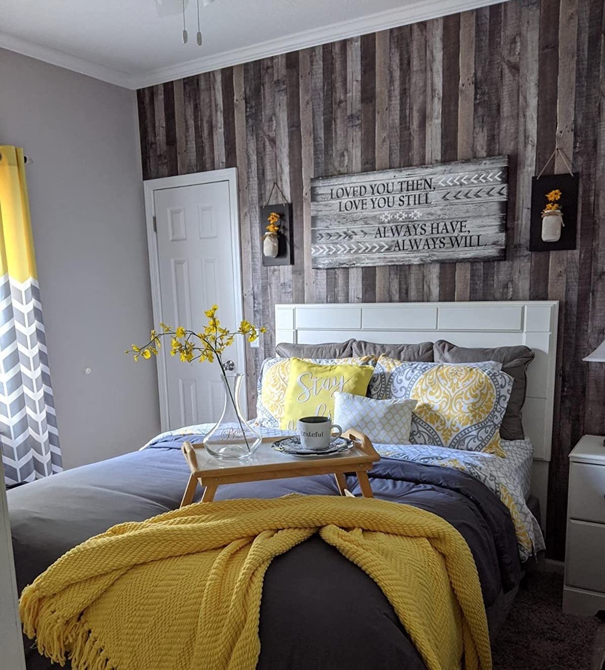 Reviewer&#x27;s bedroom shows the faux wood wallpaper on the wall
