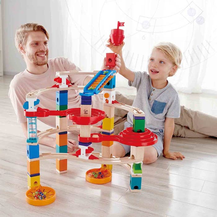 Adult and child models playing with block set and marbles