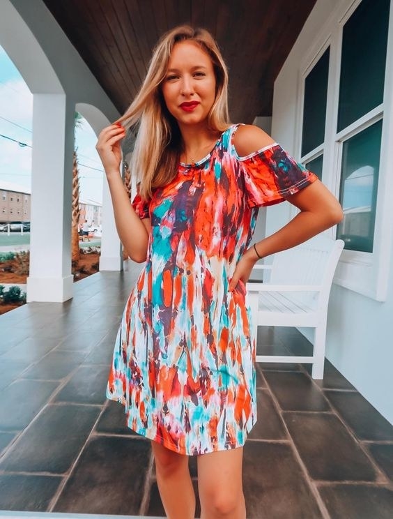 reviewer wearing the dress in a white, blue, and red pattern
