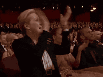 Meryl Streep cheers with Jennifer Lopez while they sit front row at an awards show