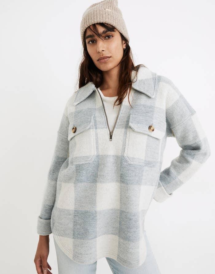 a model in a light blue and white buffalo check half zip top