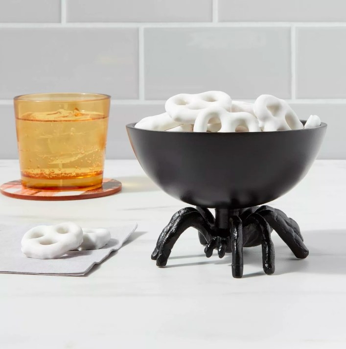 The black candy bowl holding white chocolate covered pretzels