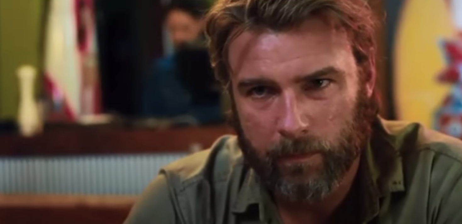 A close up of Liev Schreiber as he rocks a full beard and looks towards the camera
