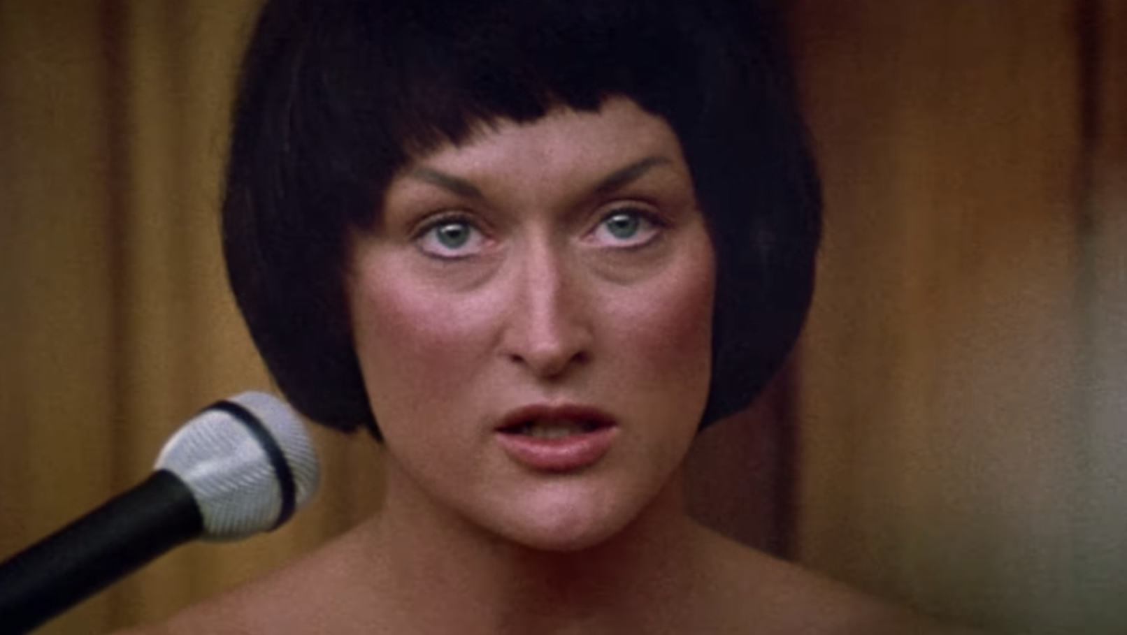 A close up of Meryl Streep as she wears a dark colored bob wig