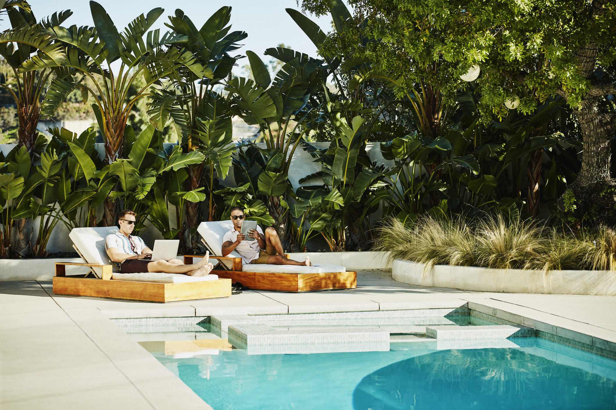 Two people lounging by a pool