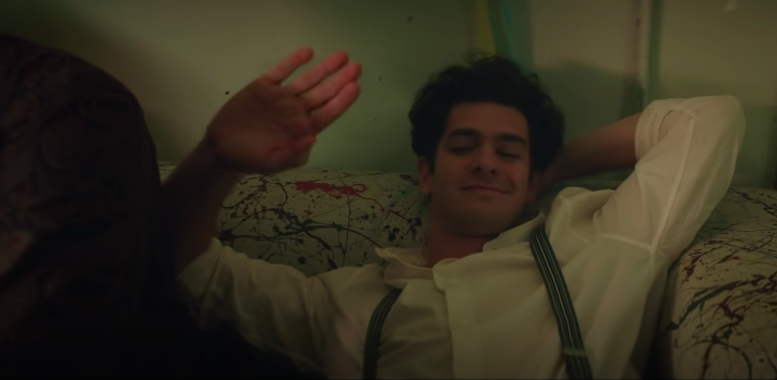 Andrew Garfield smiling as he lays in bed