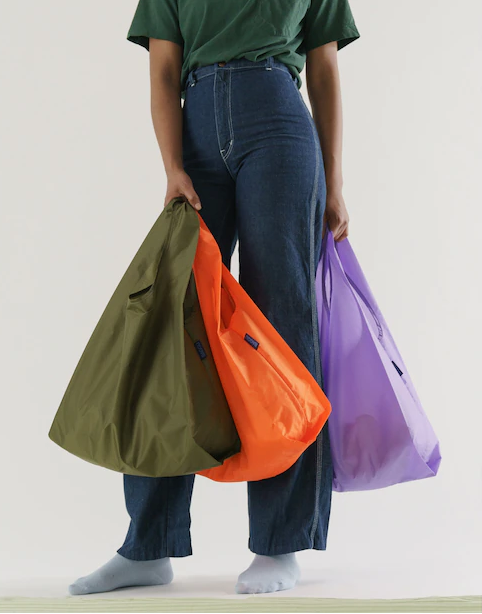 A person holding a bunch of full shopping bags