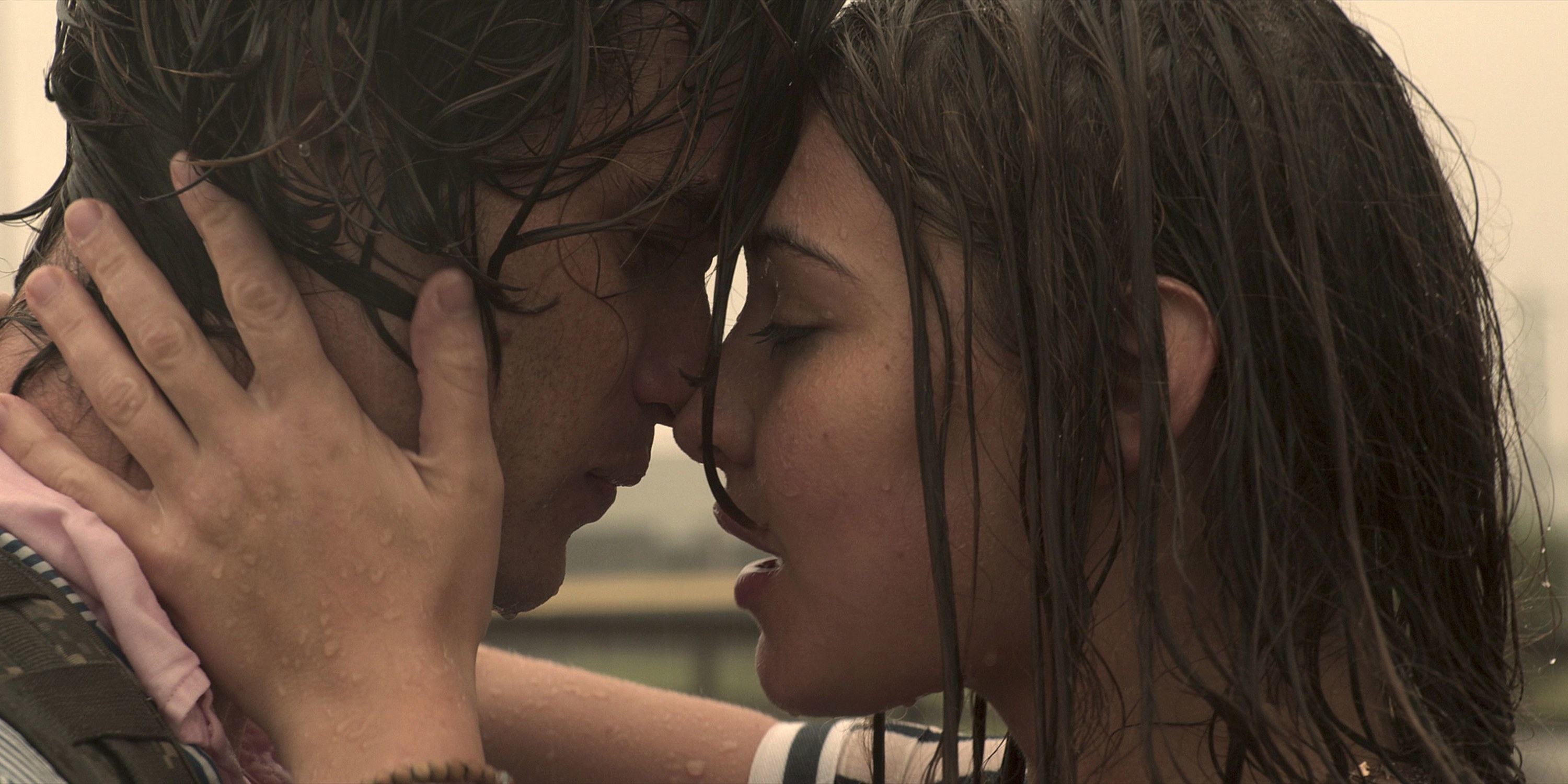 John B. and Sarah kiss in the rain.
