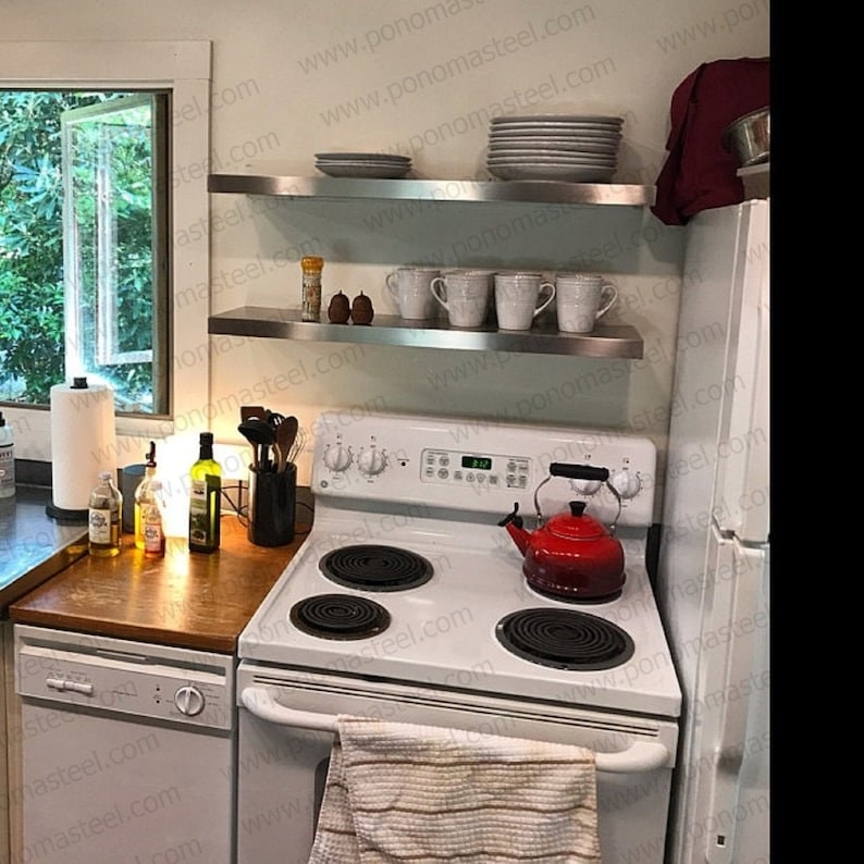 a kitchen with the stainless steel shelves above the oven