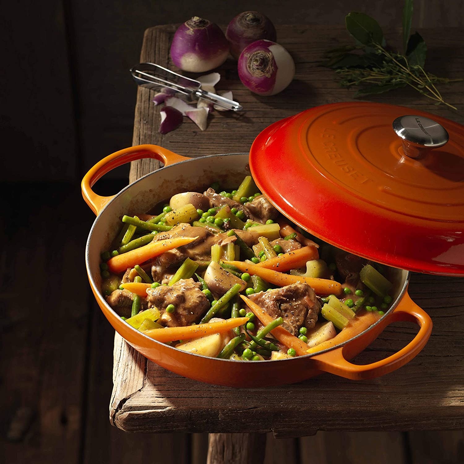 the pan in ombre orange with beef, potatoes, carrots, and peas