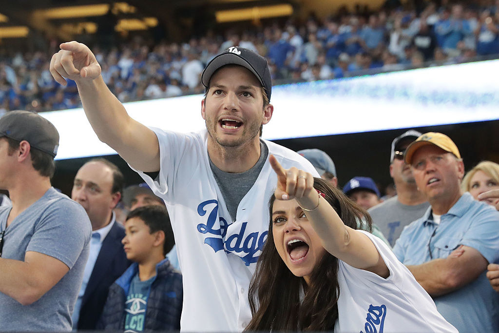 Mila Kunis (R) and Ashton Kutcher cheer in support of the Los Angeles Dodgers