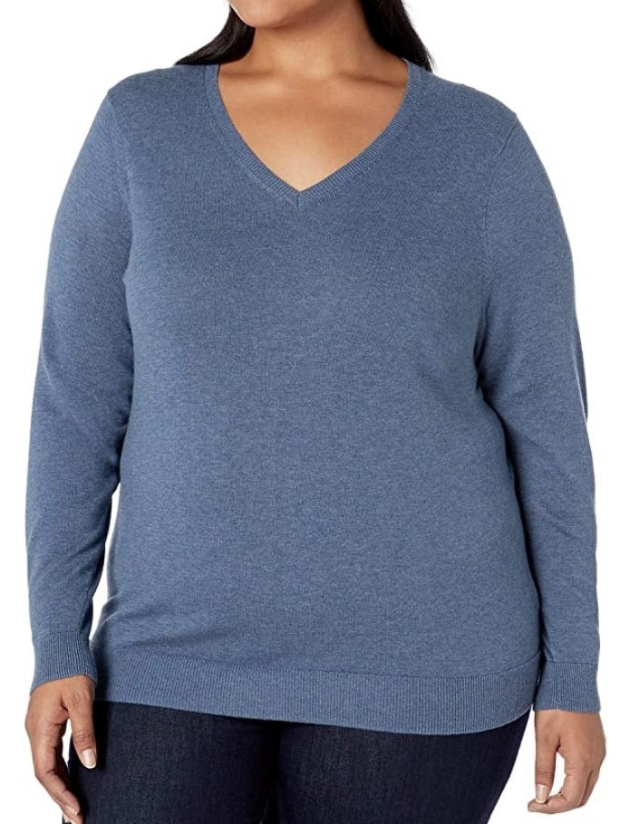 A model wearing a blue heather, long sleeve v-neck sweater