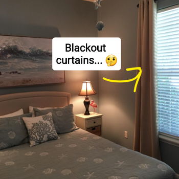 reviewer's bedroom with the beige blackout curtains pulled open to show daylight outside