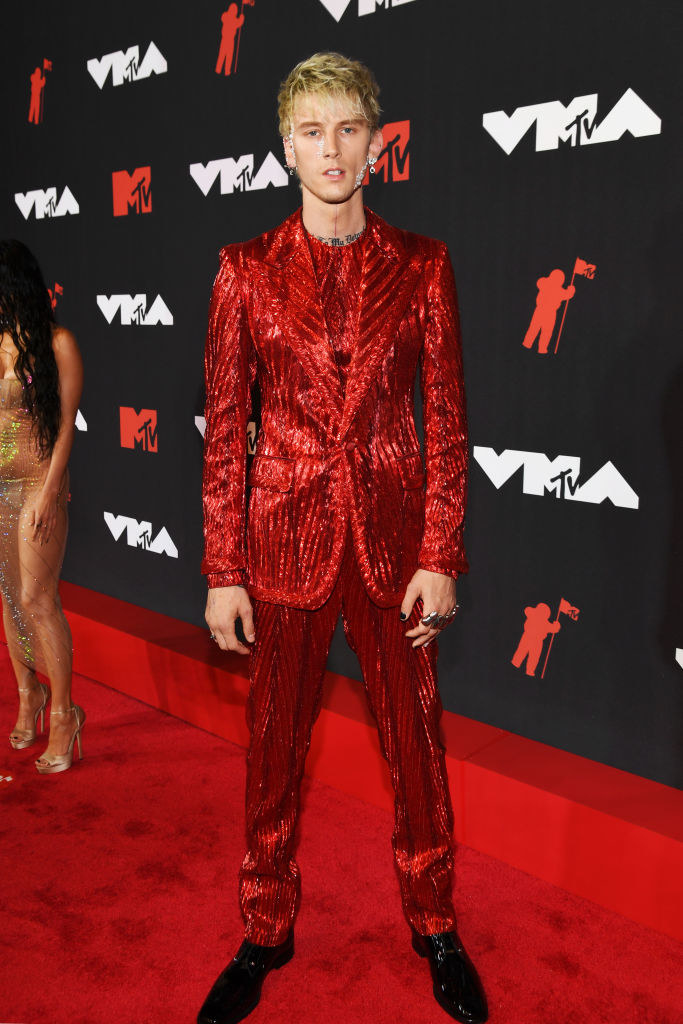 Machine Gun Kelly on the red carpet in a metallic red suit