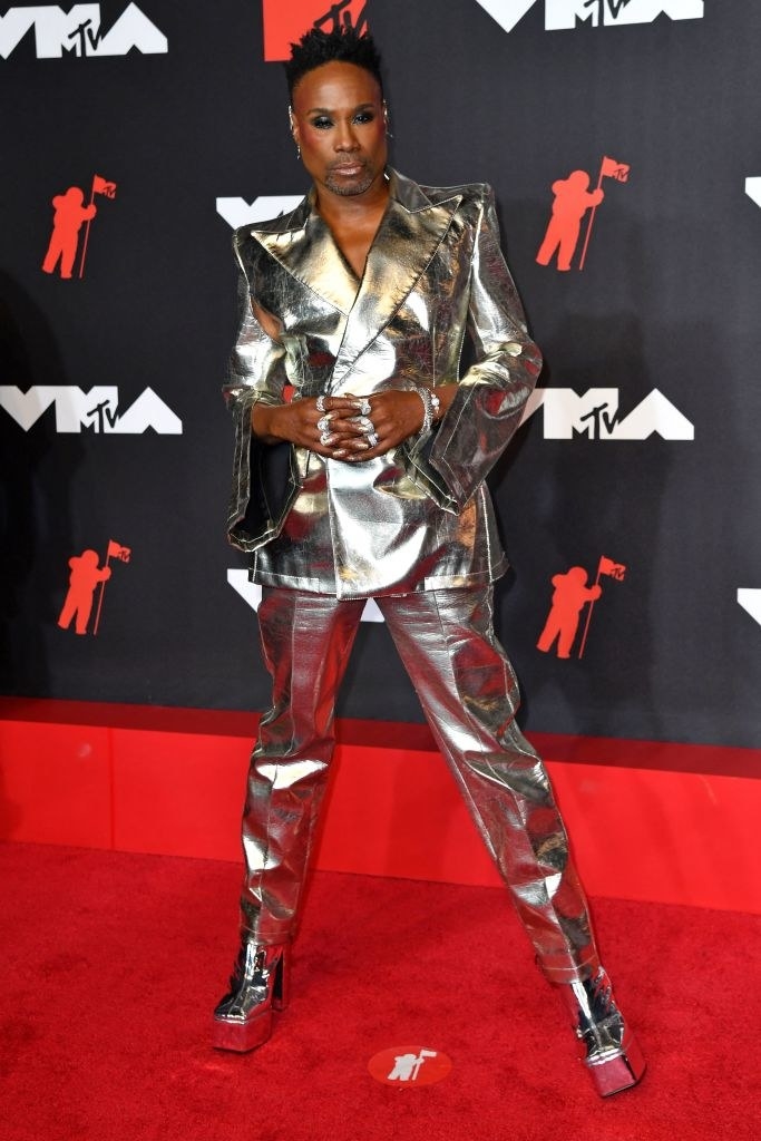 Billy Porter on the red carpet in in an all silver suit and platform heels
