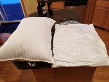 A flattened pillow in plastic next to another pillow that has fully inflated