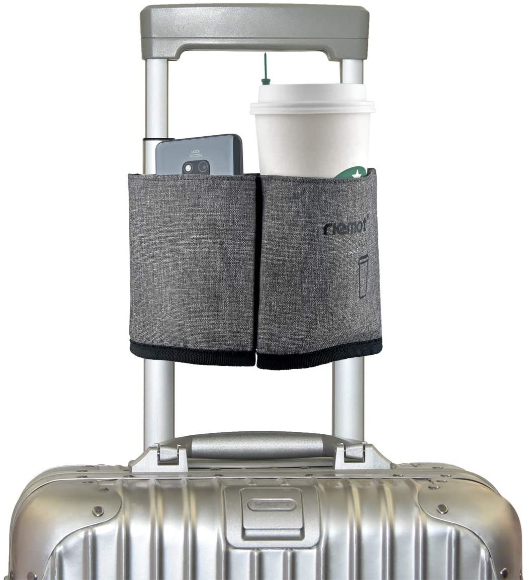 A photo of the gray cup caddy holding a Starbucks coffee and cellphone attached to a carry-on suitcase handle