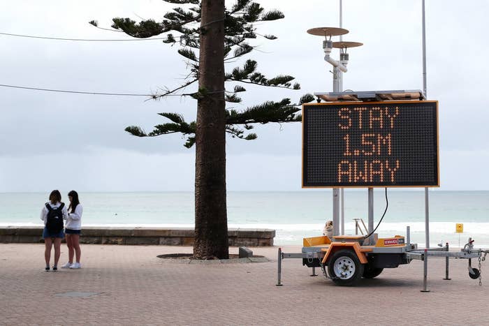 A sign reminding residents and tourists of new social distancing rules is displayed at Manly Beach