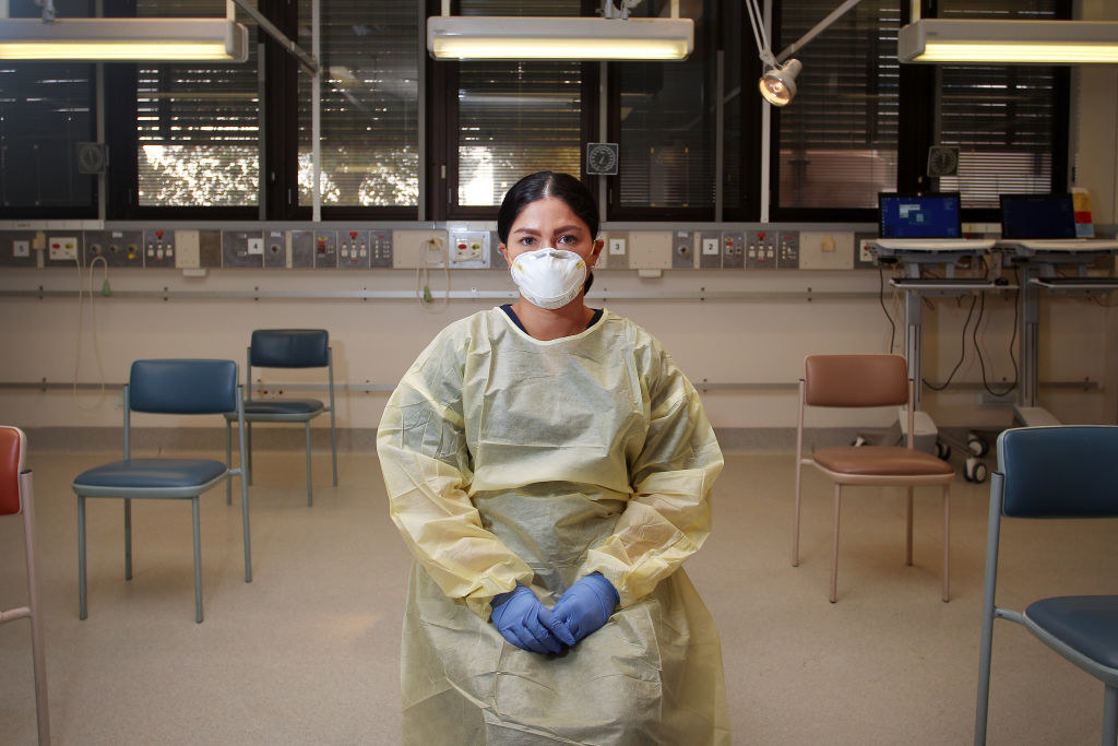 A nurse dressed in PPE sitting down