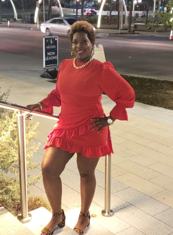 A reviewer wearing a red, long-sleeve, wrap dress with ruffled detailing