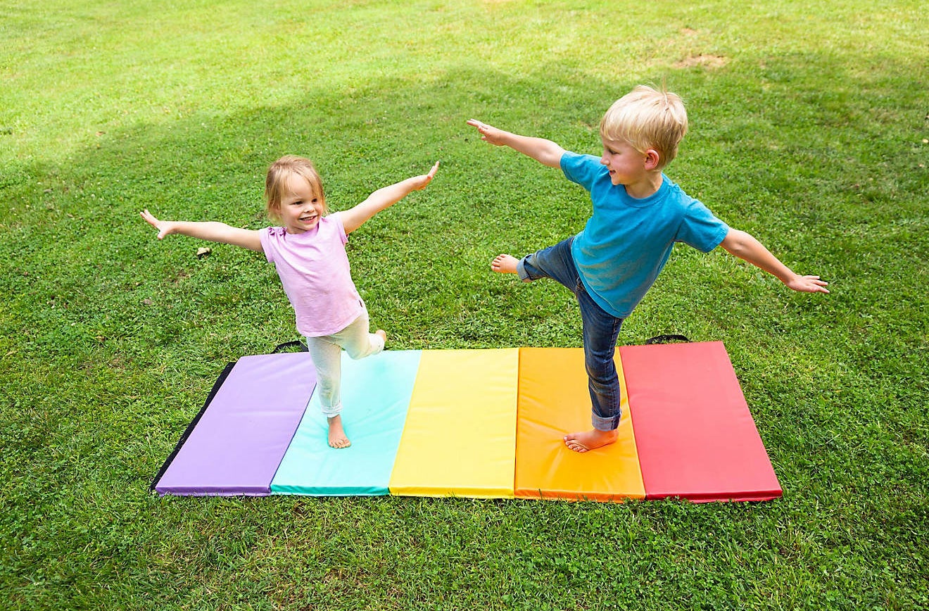 Two kids playing on the mat