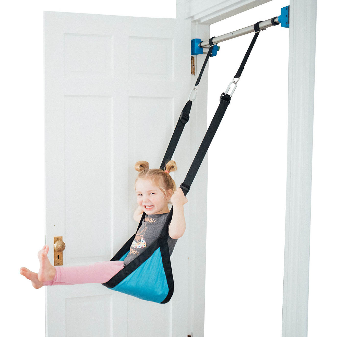 A child smiling while she uses the indoor swing
