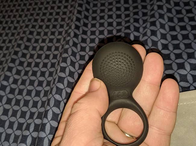 reviewer holding cock ring to display textured bottom