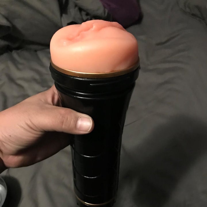 Model holding black and pink realistic masturbator