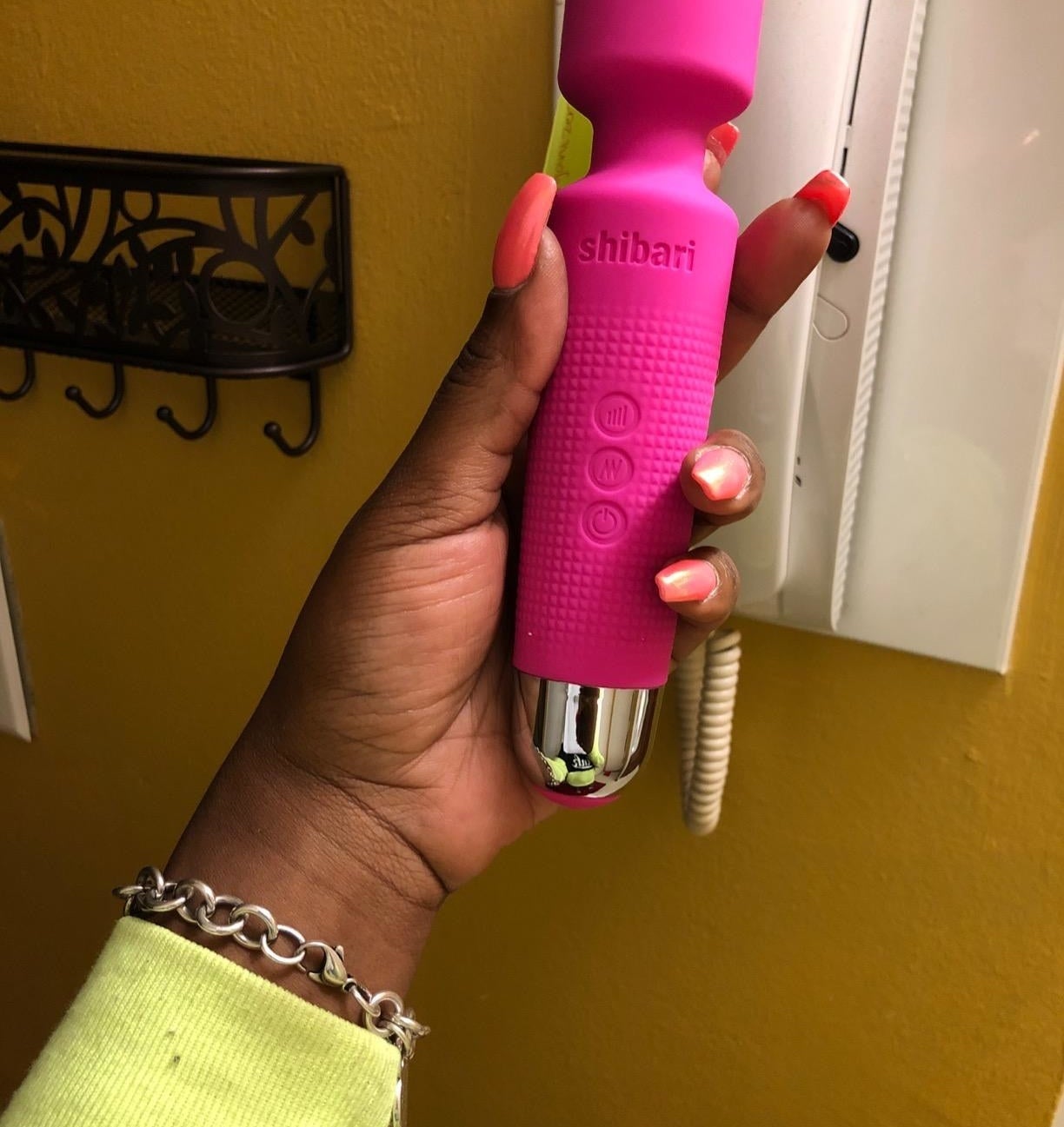 reviewer holding pink wand vibrator