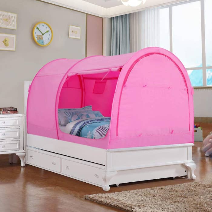 the pink bed tent over a twin bed with an unzipped entrance
